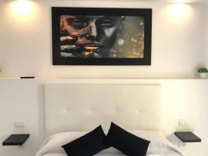 uma imagem pendurada por cima de uma cama num quarto em Balcon Atlantico Holiday Tenerife em Adeje