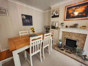 a dining room with a table and chairs and a fireplace at Frankland - Emsworth Harbour 3 Bedroom House in Emsworth