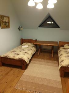 Ranna的住宿－Rannamõisa Puhkeküla，一间设有两张床和一张桌子的房间