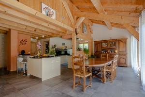 a kitchen and dining room with a wooden ceiling at Chalet aux 3 biches in Mieussy