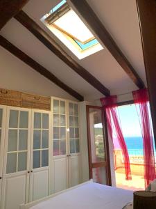 a bedroom with a bed and a window with the ocean at Residence Lu Bagnu in Castelsardo