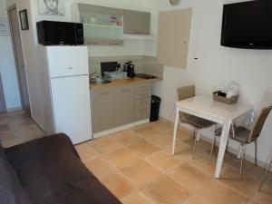 una pequeña cocina con mesa y nevera blanca en Joli appartement dans village calme en Provence, en Les Mées