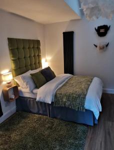 a bedroom with a large bed with a headboard at The Coo Shed in Balfron