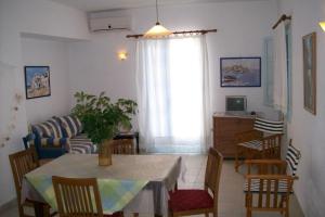 a living room with a table and chairs and a couch at Daira Apartments in Diakofti