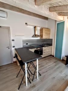 cocina con mesa negra en una habitación en Il B&B di Piazza Motta, en Albese Con Cassano