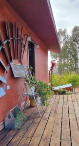 een houten terras met een bank en een gebouw bij Viña Calabria in Valle de Guadalupe