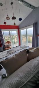 a bedroom with a large bed with a large window at Viña Calabria in Valle de Guadalupe