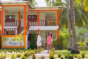 two women standing in front of a house at Playa Mareygua Hostal in Buritaca