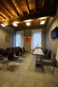 una sala conferenze con sedie e tavolo in legno di Albergo Morandi a Reggio Emilia