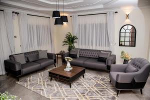 a living room with two couches and a coffee table at Lux Suites Eldoret Luxury Villas in Eldoret