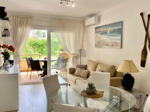 Una sala de estar con una mesa de cristal y un sofá. en Apartamentos Stil Mar Anna - Stil Mar Anna L'Escala 4, en L'Escala