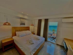 a bedroom with a bed with a view of the ocean at Hotel Pefkohori Beach in Pefkochori