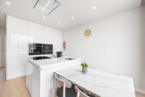 a kitchen with white cabinets and a white counter top at Ocean Apartment by Olala Homes in Cascais