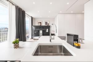 a kitchen with a stainless steel sink and a large window at Ocean Apartment by Olala Homes in Cascais