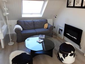 un salon avec un canapé et une table dans l'établissement Sixtyfour penthouse, à Knokke-Heist