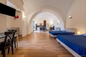 a room with two beds and a table and a kitchen at Villa Vesuviana in Torre del Greco