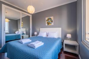 a bedroom with a blue bed with towels on it at Canico Vip Lodging by Homie in Santa Cruz