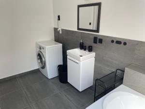 a bathroom with a washing machine and a sink at Apartmán Věra in Pardubice