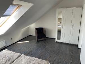 Habitación en el ático con cama y silla en Apartmán Věra, en Pardubice