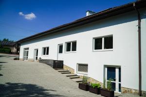 a white building with some plants in front of it at Agroturystyka Mazal Dukla in Dukla
