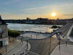 vista su un fiume e su una città con il tramonto di Le WILSON - BLOIS CENTRE - VUE LOIRE a Blois