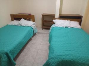 dwa łóżka siedzące obok siebie w pokoju w obiekcie la casa de la guajira w Cuzco