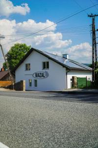 a white building with a sign on the side of it at Apartamenty Mazal Dukla in Dukla