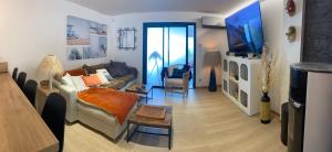 a living room with a couch and a flat screen tv at Little Bohême, luxe, piscine, SPA, tout à pied, Port Grimaud in Grimaud