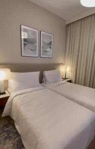 a large white bed in a hotel room with two lamps at Apartments with three bedrooms at address hotel in Sharm