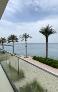 d'un balcon avec des palmiers offrant une vue sur l'océan. dans l'établissement Apartments with three bedrooms at address hotel, à Sharm