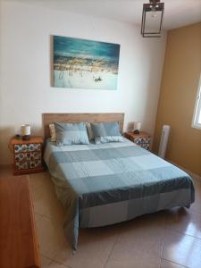 a bedroom with a large bed with a blue comforter at Jandia Beach in Morro del Jable