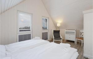 オルペニッツにあるNice Home In Ostseeresort Olpenitz With Kitchenの白いベッドルーム(ベッド1台、椅子付)