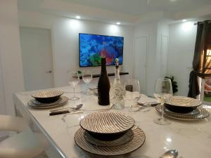 una mesa de comedor con platos y copas de vino. en Balcon Atlantico Holiday Tenerife, en Adeje