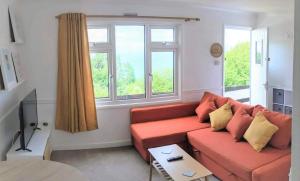 a living room with a couch and two windows at Parkdean Sea Valley chalet Westward Ho! & Bideford in Bideford