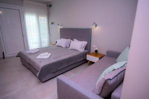 a bedroom with a bed and a couch at Olea Garden Apartments in Stavros