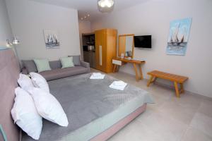 a living room with a couch and a tv at Olea Garden Apartments in Stavros