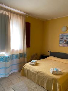 ein Schlafzimmer mit einem Bett und einem Fenster mit Handtüchern darauf in der Unterkunft Agriturismo Simbirizzi in Quartucciu