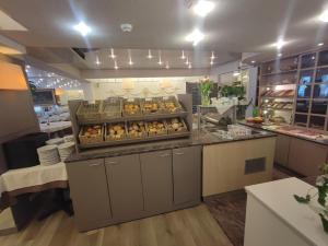 a bakery with a counter with trays of pastries at Hotel Glenmore in Ostend