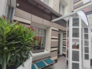 un balcon avec des plantes et une fenêtre sur un bâtiment dans l'établissement Hotel Glenmore, à Ostende