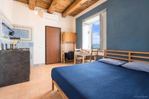 a bedroom with a bed and a kitchen and a table at Villa Vesuviana in Torre del Greco