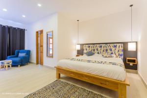 una camera con letto e sedia blu di L'imprévu L'annexe a Cotonou