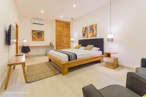 a bedroom with a king sized bed and a couch at L'imprévu L'annexe in Cotonou