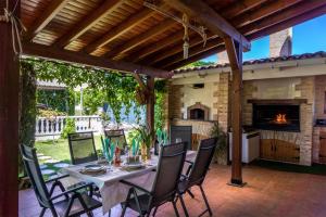 une table et des chaises sur une terrasse avec une cheminée dans l'établissement Lujosa Casa Rural el Altico con barbacoa, chimenea y zona infantil, à Cehegín