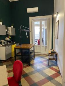 a kitchen with a table and a red chair at DS Apartments in Catania