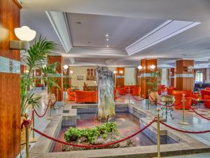 eine Hotellobby mit einem Brunnen in der Mitte in der Unterkunft Hotel Caesar Palace in Giardini-Naxos