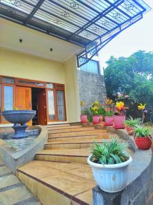 a patio with a fountain and potted plants at Homestay Parikesit Rent Full House in Semarang