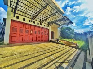 una casa con porte rosse e pavimenti in legno di Homestay Parikesit Rent Full House a Semarang