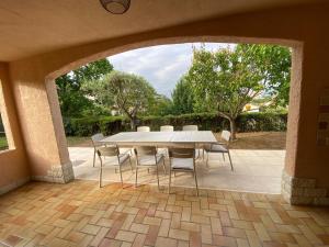 - une table et des chaises dans une terrasse avec une arche dans l'établissement Holiday home "225 Marc Chagall", à Mandelieu-la-Napoule