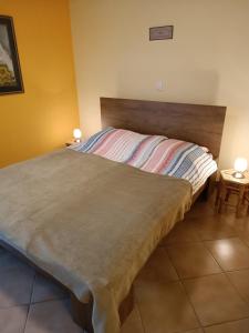 1 cama en un dormitorio con 2 lámparas en 2 mesas en Apartma sobe Tina Bled, en Bled