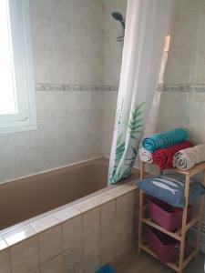 a bathroom with a tub and a shelf with towels at appartement malo les bains plage in Dunkerque